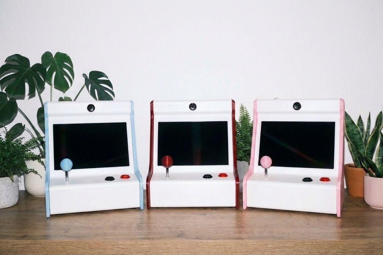 Drei Klicki-Boxen mit blauen, roten und rosa Panels, Joysticks und Buttons